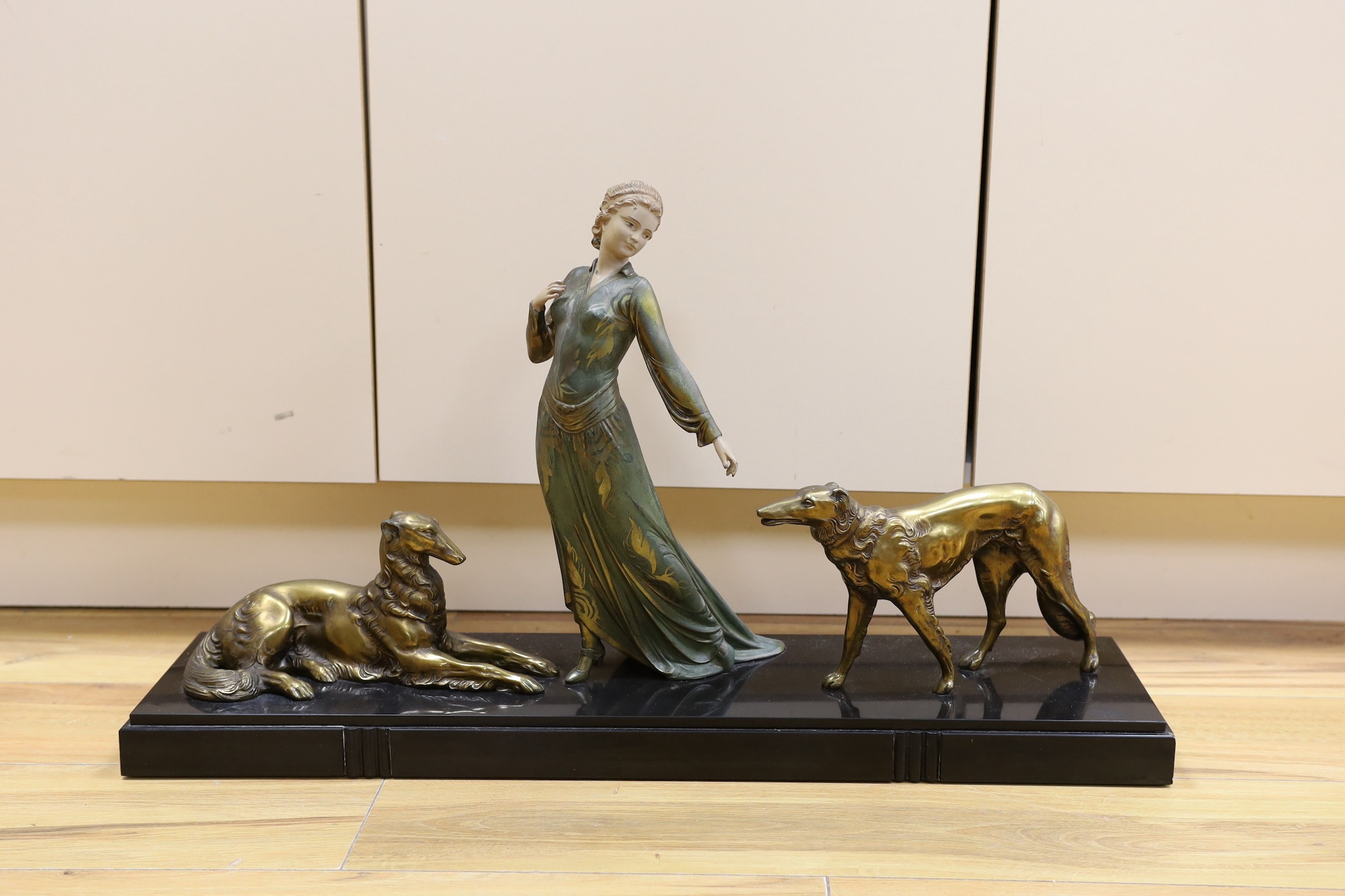 A French Art Deco female spelter figure and two bronzed spelter dogs on black marble base, signed Roggia. 74cm wide